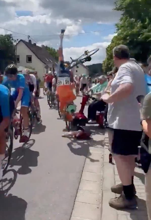 Elderly woman on mobility scooter drives into bike race, causing mass collision as cyclists somersault over handlebars: video